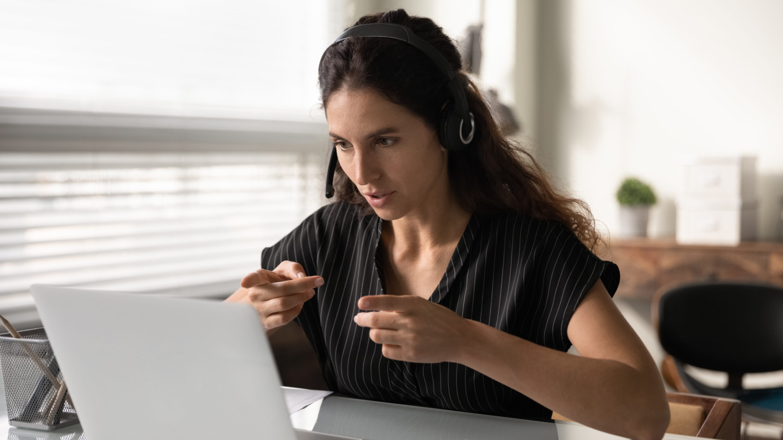 Woman using ASL in front of a laptop