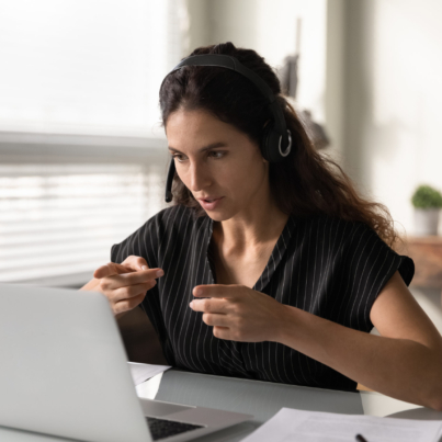 Woman using ASL in front of a laptop