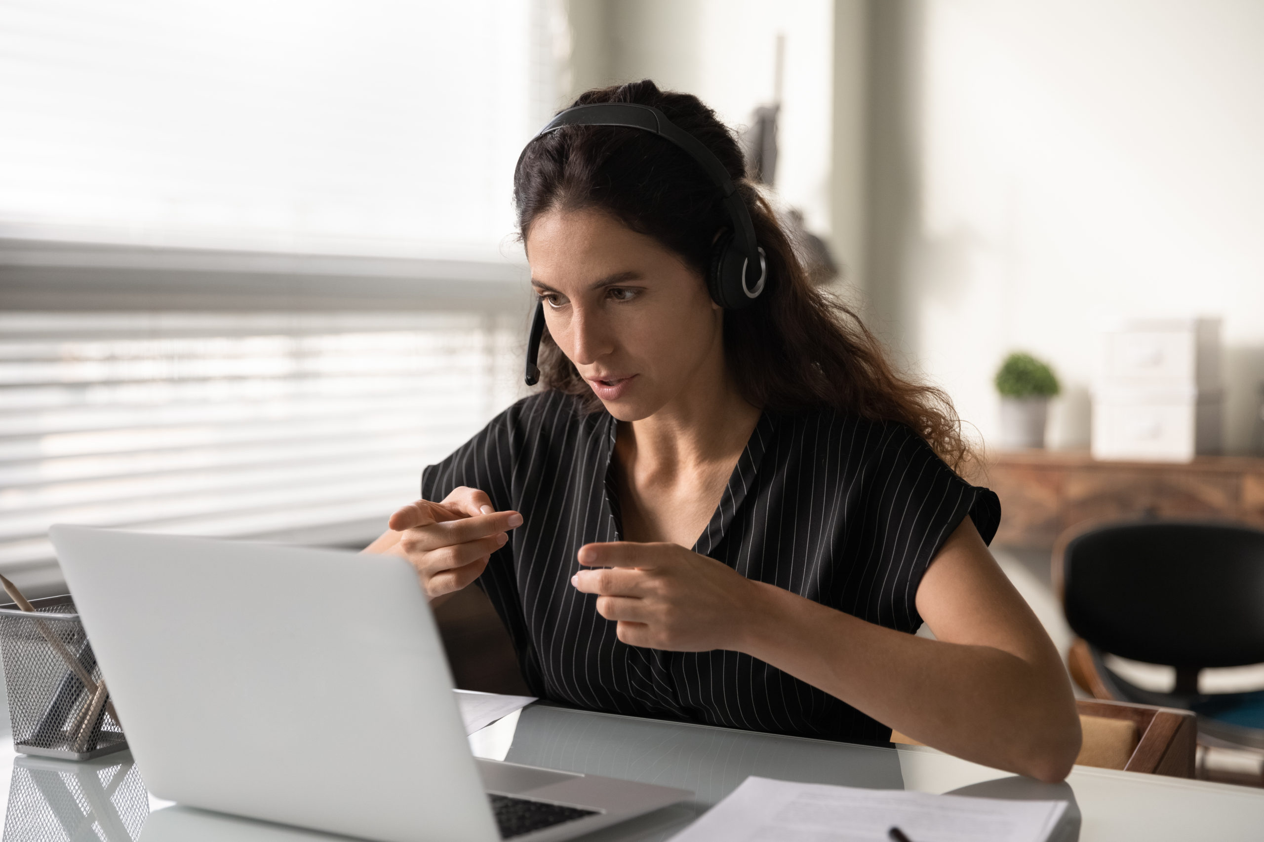 Woman using ASL in front of a laptop